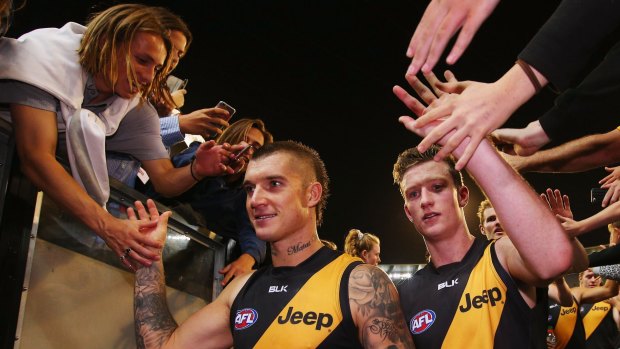 Well done: Dustin Martin celebrates with fans as he leaves the ground after the win over Carlton.