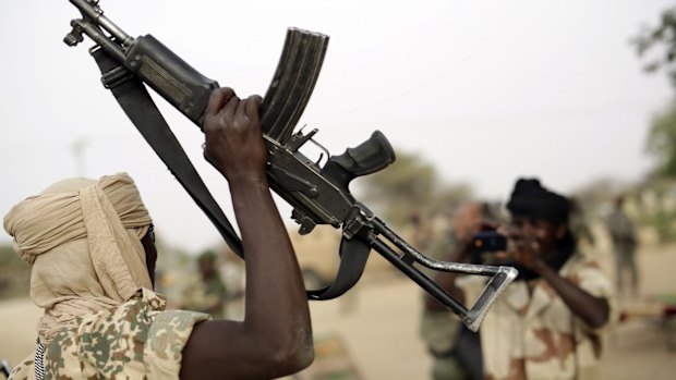 A Chadian soldier raises his automatic weapon to have his picture taken by another soldier  in the Nigerian city of Damasak in March. The Cameroon's army, backed by a regional force that includes Chad, have rescued 900 hostages and killed 100 Boko Haram jihadists.