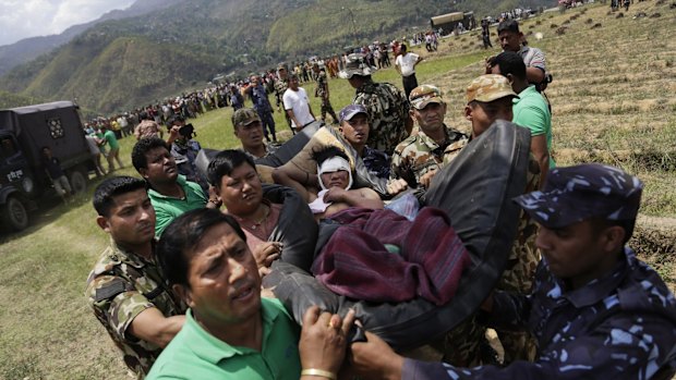 Nepalese soldiers carry a wounded man on a makeshift stretcher to a waiting Indian Air Force helicopter as they evacuate victims of Saturday's earthquake from Trishuli Bazar to Kathmandu airport in Nepal.