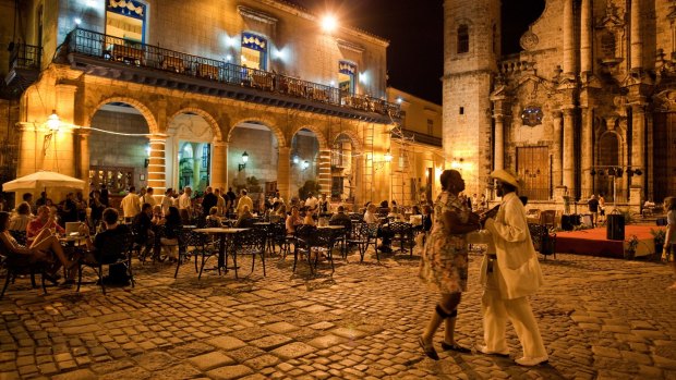 An outdoor restaurant and Salsa dancers on the cobble stoned Plaza Catedral in Old Havana.