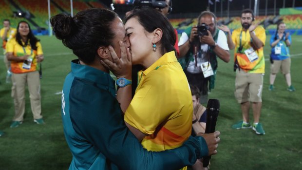 Volunteer Marjorie Enya (R) and rugby player Isadora Cerullo of Brazil kiss after the marriage proposal. 