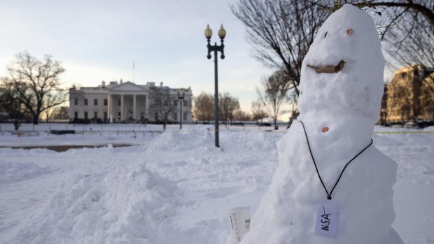 A snowman with a pretend National Security Agency badge and a coffee cup stands in Lafayette Square Park, across from the White House in Washington on Monday.