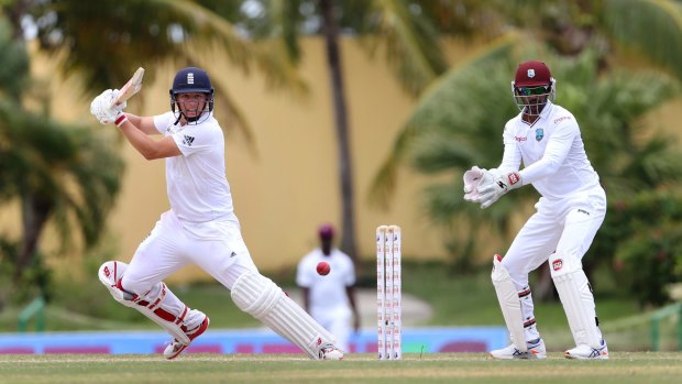 England's Gary Ballance hits a four as West Indies' Denesh Ramdin looks on.