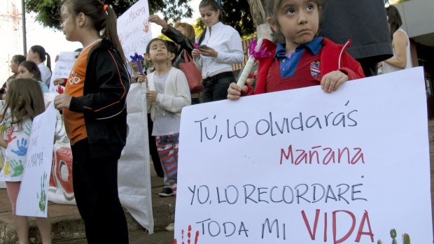 A young girl holds a sign reading in Spanish "You'll forget it tomorrow, I will remember it all my life" at a demonstration in front of the attorney-general's office in Ciudad del Este, Paraguay, on Monday. 