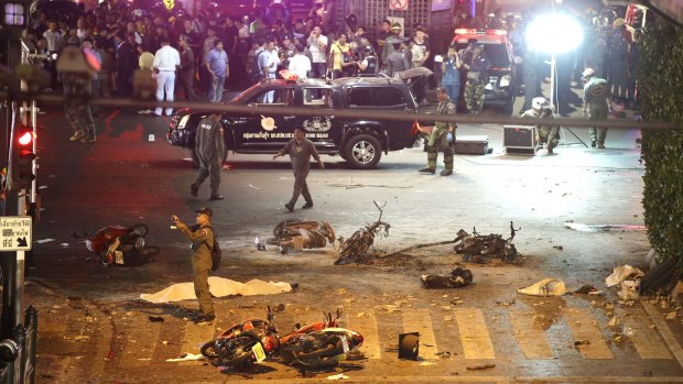 A policeman photographs debris after the August 17 explosion in central Bangkok.