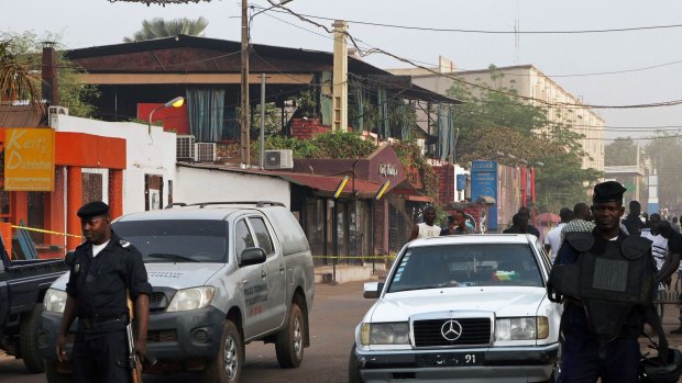 Policemen guard the La Terrasse restaurant (in the backround with blue curtains) after the attack in Bamako.