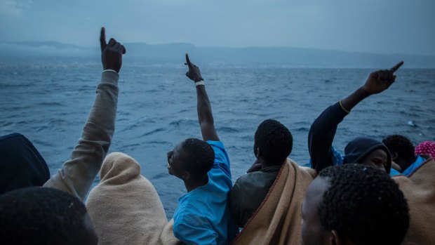 African men celebrate their arrival in Italy aboard a Spanish NGO Proactiva Open Arms ship, after being rescued off Libya last month.