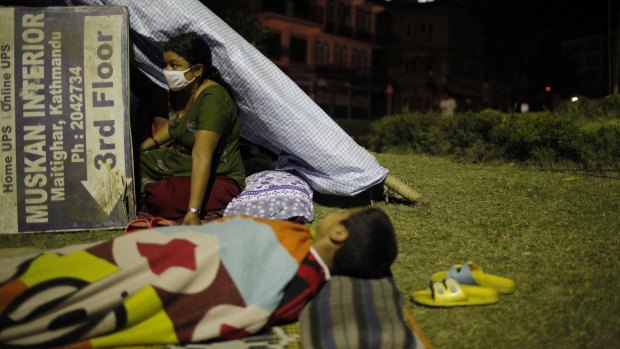 A Nepalese woman sits inside her makeshift tent in an open space in Kathamandu, Nepal after a second quake struck.