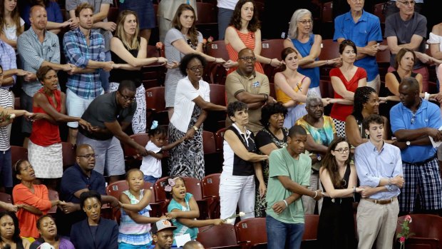 Thousands of people hold hands and sing during a prayer vigil for the nine victims.