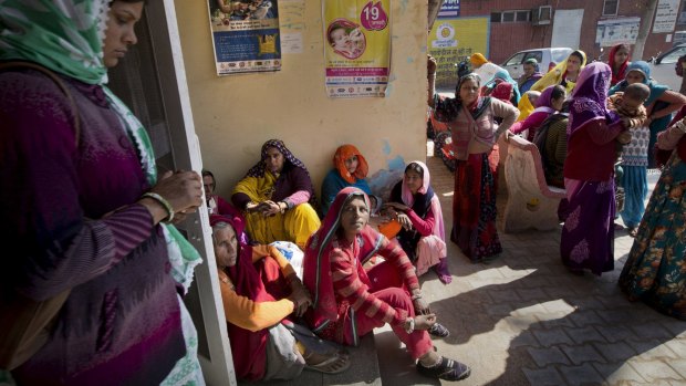 Relatives of women who are going through sterilisation surgery wait outside a government hospital in Mahendragarh.