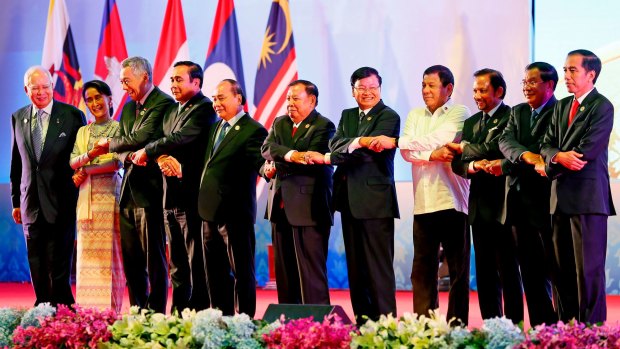 Southeast Asian leaders link arms in Vientiane, Laos. Cambodia's Prime Minister Hun Sen is second right.
