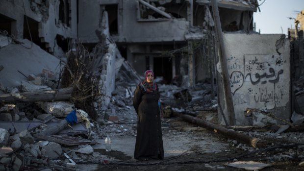 A woman stands outside a destroyed building in Shu Jaia, Gaza. 