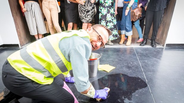 Adam Bandt cleaning the floor of ACCA as part of artist Nat Thomas installation <i>Man Cleaning Up</i>. 