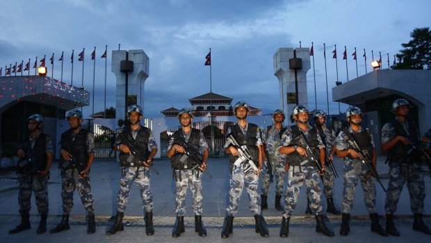 Nepalese policemen stand guard in front of the constituent assembly hall where a ceremony to adopt the country's new constitution was in progress in Kathmandu on Sunday.