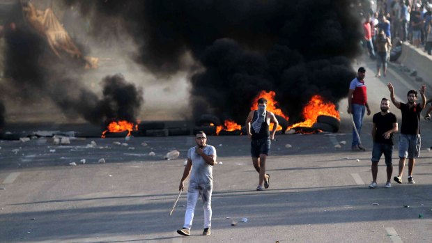 Lebanese protesters set fire to tires in Jiyeh, southern Lebanon, to block the highway and make a point about garbage.