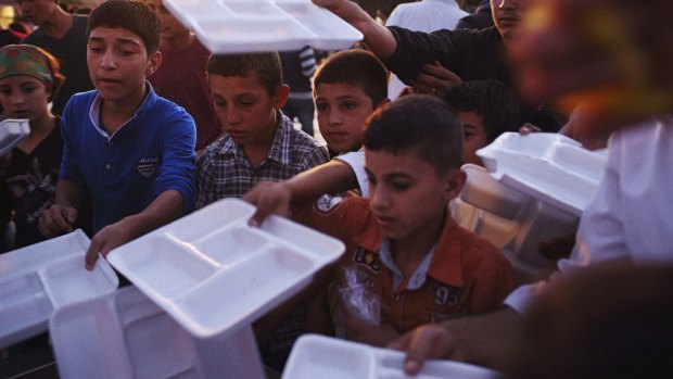 Displaced Syrian Kurdish children queue for food in Suruc in October, the nearest town to the Turkish border. 
