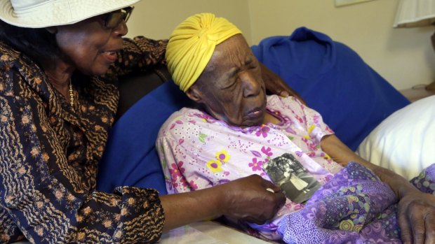 Lois Judge, left, holds a 1939 photo of her aunt Susannah Mushatt Jones, right, last year. Jones has died at the age of 116.