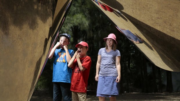 From left, brothers Ben Davies, 11, and James Davies, 8, of Melbourne with mum Melanie Davies, clowning around with their reflections in the sculpture cones by Bert Flugelman  at the National Gallery of Australia.