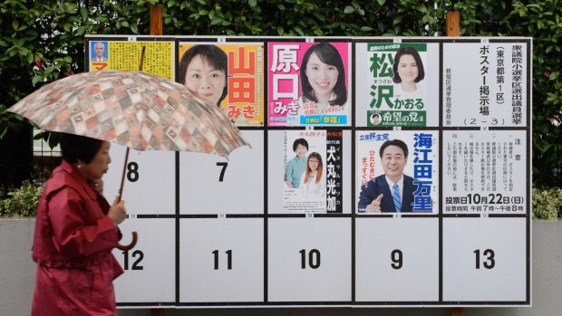 A pedestrian walks past campaign posters of various candidates running in a general election in Tokyo on Sunday.
