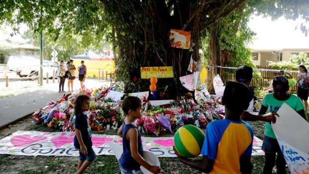 Children leave paintings and toys at a tree near the house in Cairns.