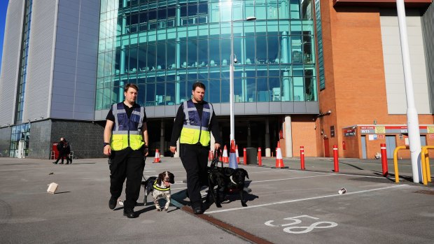 Stewards with sniffer dogs on the scene following a security alert and the abandonment of the Barclays Premier League match between Manchester United and AFC Bournemouth at Old Trafford.