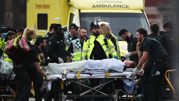 A member of the public is treated by emergency services near Westminster Bridge and the Houses of Parliament on Wednesday.