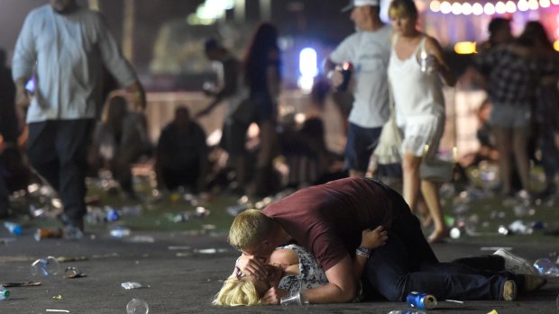People lie on the ground at a country music festival in Las Vegas after a shots were fired at the concert.
