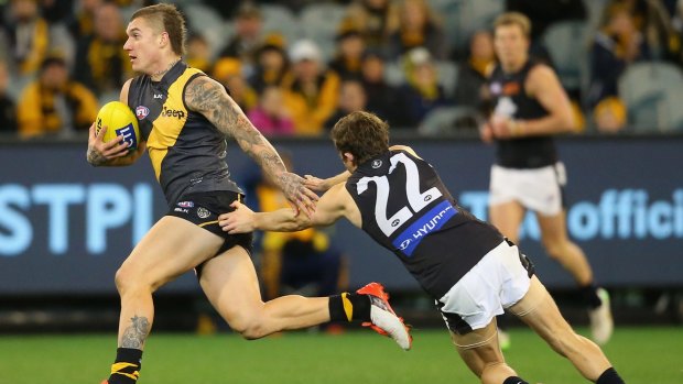 Can't catch me: Richmond's Dustin Martin fends off an attempted tackle by Jason Tutt of the Blues.