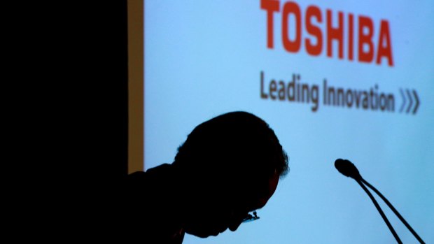 Toshiba chief executive Satoshi Tsunakawa bows during a news conference at the company's Tokyo headquarters in which he warned of the company's financial position. 