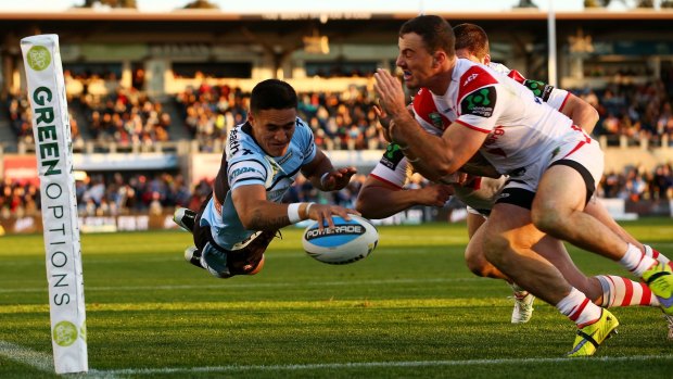 Lovely stuff: Valentine Holmes flies over for a try to Cronulla.