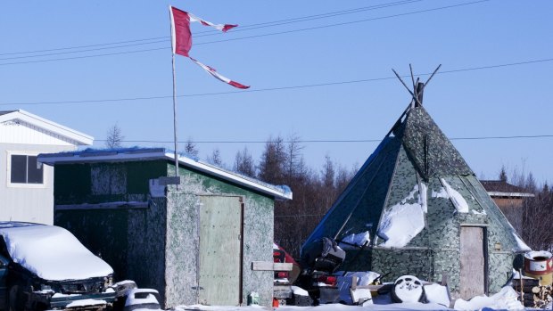 The remains of a Canadian flag fly over a building in Attawapiskat, a community plagued by suicides in Canada.