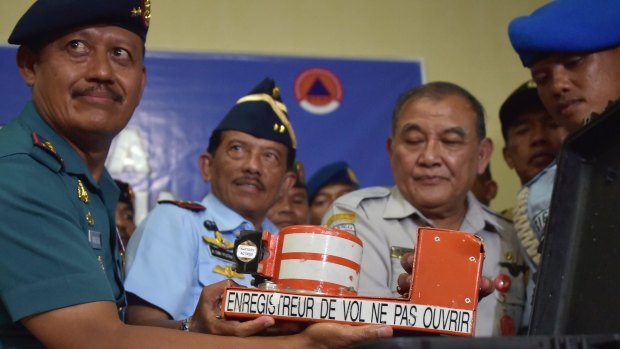 Indonesia's head of the Military Search and Rescue Task Force Widodo (left) holds the cockpit voice recorder from AirAsia flight QZ8501.