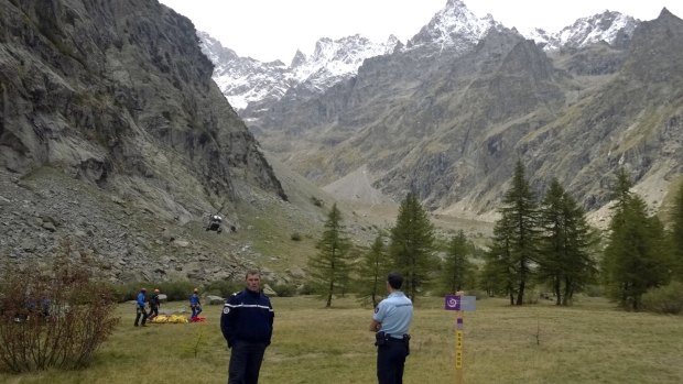 French gendarmes stand before a rescue helicopter lands after an avalanche in the French Alps swept seven climbers to their deaths on Tuesday.