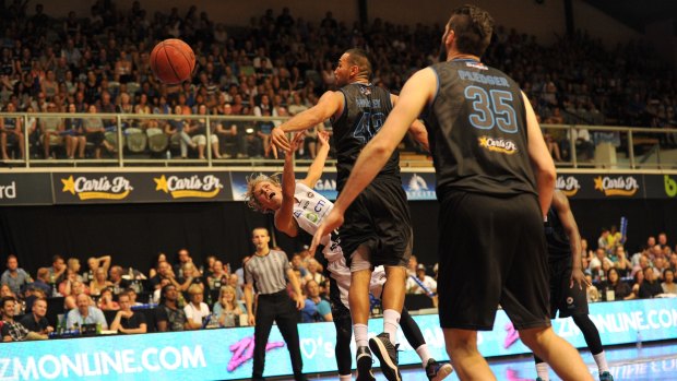 Melbourne United's Kyle Adnam is fouled by New Zealand's Tai Wesley.