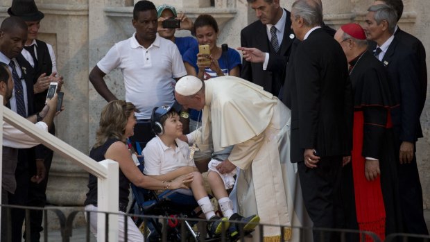 Pope Francis greets a child on a wheelchair during a meeting with a group of Cuban youth in Havana on Sunday. 