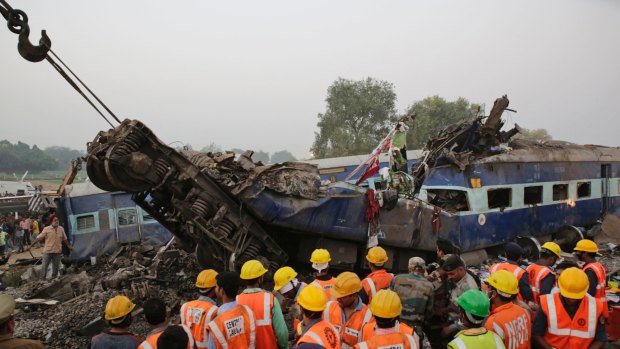 Rescuers search among the debris after 14 coaches of an overnight passenger train rolled off the track near Pukhrayan village in Uttar Pradesh state, India on Sunday.