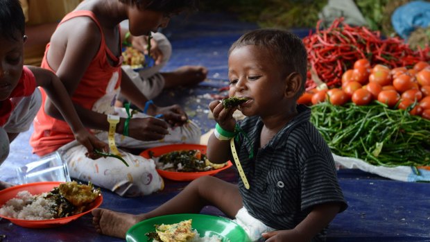 Bangladeshi children eat meals provided by Indonesian volunteers at a confinement area for migrants at Bayeun, Aceh, Indonesia on Saturday.