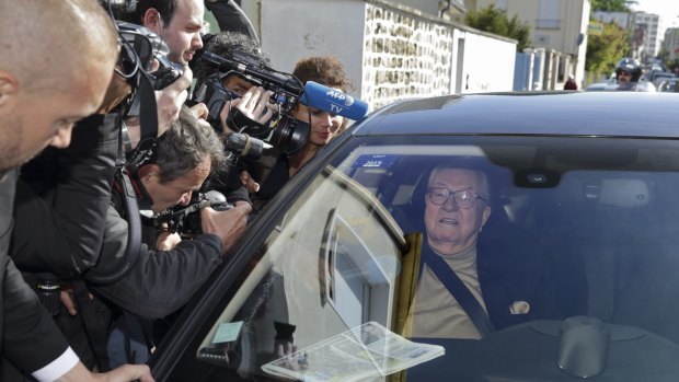 France's far-right National Front founder and honorary president Jean-Marie Le Pen is surrounded by journalists as he arrives at the party's executive office in Nanterre near Paris on Monday. 