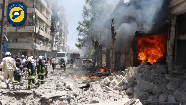Syrian civil defence workers gather in a street  attacked by warplanes in Aleppo.