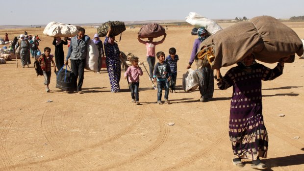 Syrian Kurdish refugees head for the Turkish town of Suruc on Tuesday.
