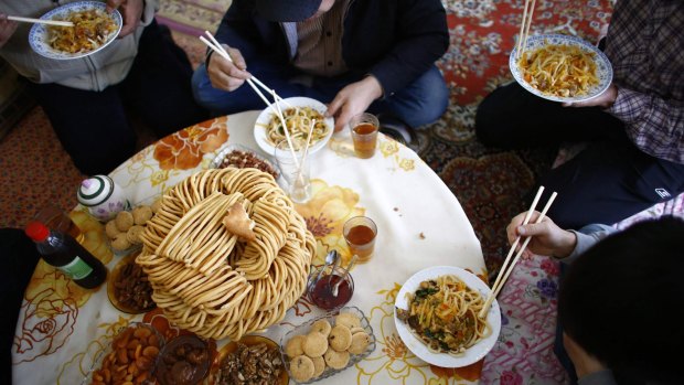 Uighur refugees eat in a gated complex  in the central Turkish city of Kayseri.