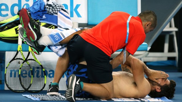 Strung out: Simone Bolelli receives treatment from a trainer.