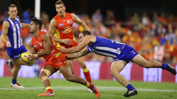 Aaron Hall of the Suns is tackled by Ben Cunnington of the Kangaroos.