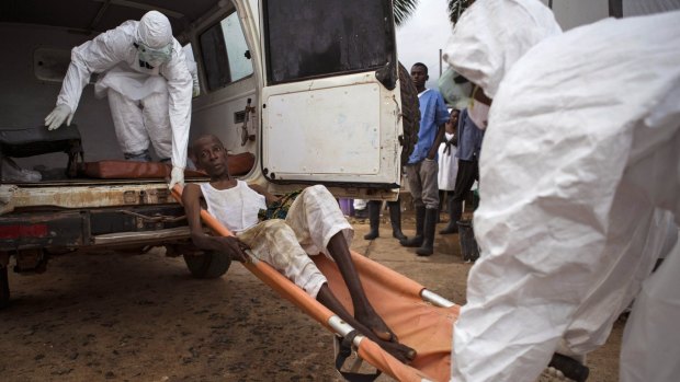 International effort: Health care workers assist a suspected Ebola sufferer in Sierra Leone. 