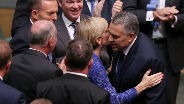 Business has praised a "softer, cuddlier budget" from Treasurer Joe Hockey, seen here congratulated by Foreign Affairs Minister Julie Bishop after handing down the Budget, but foreign aid recipients will suffer.
