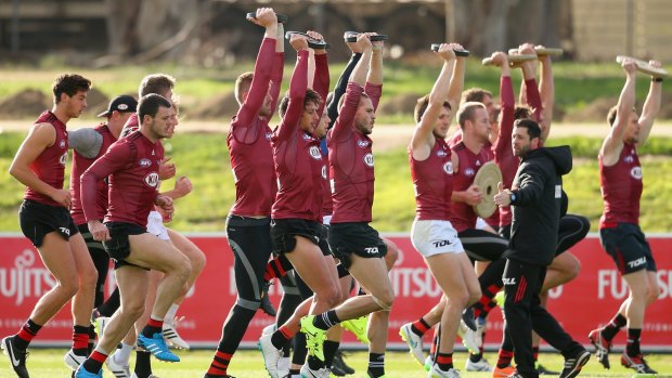 Essendon players warm up at their training venue during the week.