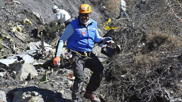 Recovery operation: A French gendarme makes his way through debris of Flight 4U 9525 in the French Alps.