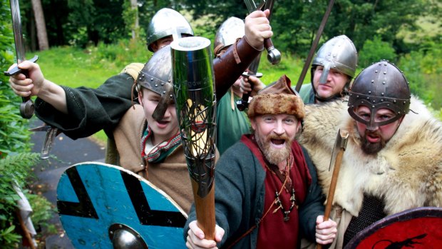 A group from the Scottish historical re-enactment group, Swords of Dalriada, hold the Glasgow 2014 Queen's Baton. Some English athletes fear that Scottish nationalists will boo them.