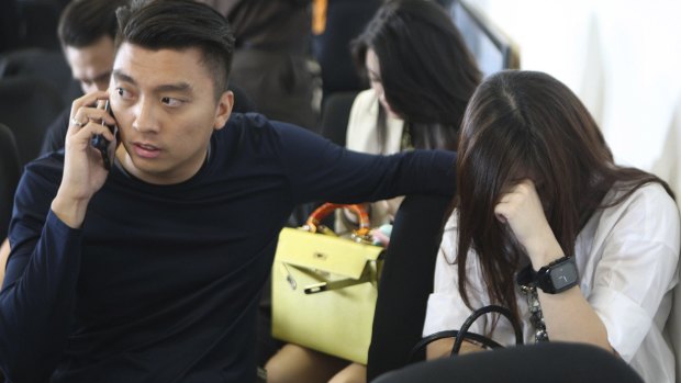 Relatives of passengers on AirAsia Flight QZ8501 wait for the latest news on the missing plane at a crisis centre at Juanda Airport in Surabaya.