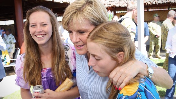 Relief: Bishop hugs Australian volunteers Mae Eldridge, left and Nina Kerridge rescued from Ambae Island. 